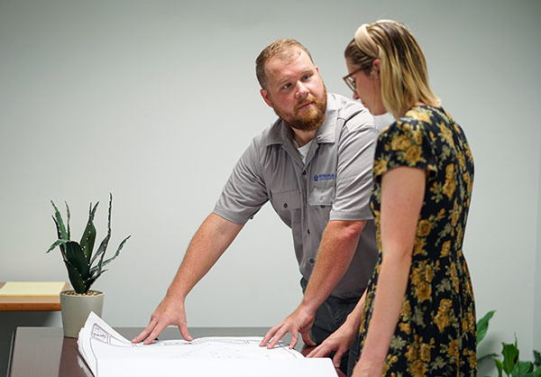 Man showing blueprints to woman